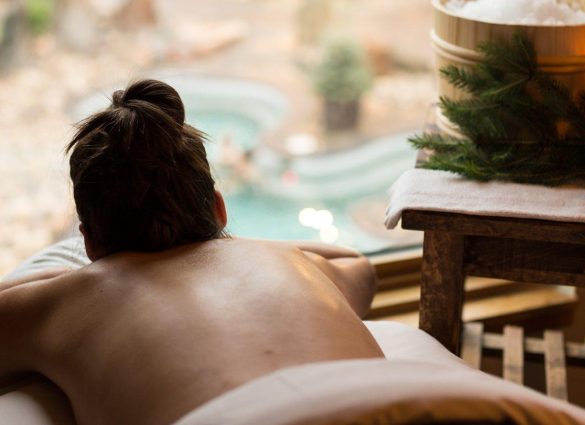 Female receiving massage at Thermea, overlooking serene grounds.