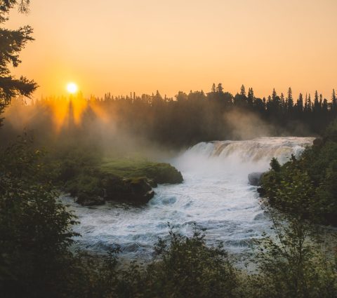 Mist rising over Pisew Falls at sunset.